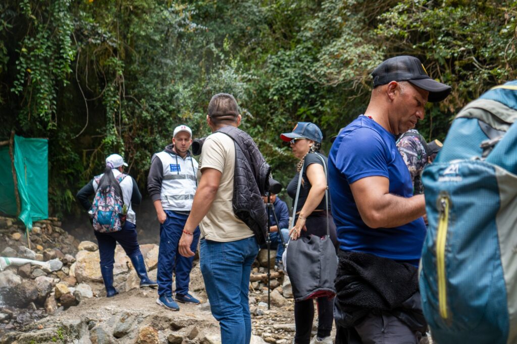 Un grupo de observadores de aves, operadores turísticos y expertos técnicos realizan un reconocimiento en la vereda Guiases, municipio de Mallama, preparándose para el Global Big Day 2026. Se observa a las personas equipadas con morrales y cámaras en un entorno de bosque húmedo característico de la biodiversidad de Nariño.