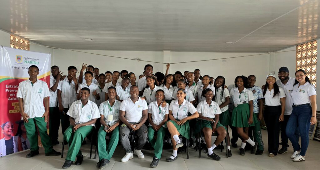 Fotografía grupal de estudiantes del Instituto Técnico Industrial Nacional (ITIN) en Tumaco junto a funcionarios de la Gerencia del Pacífico de la Gobernación de Nariño, durante una jornada de la Estrategia Integral de Prevención de Delitos en Niños, Niñas y Adolescentes.