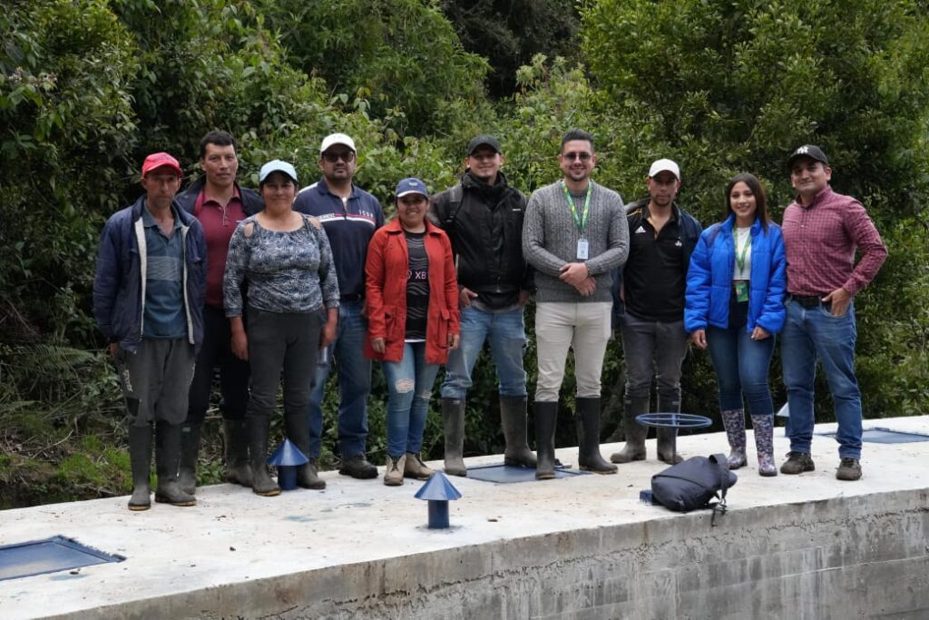 Grupo de ingenieros de la Gobernación de Nariño y habitantes de la zona rural de Túquerres posando sobre la nueva estructura de concreto del sistema de acueducto optimizado.