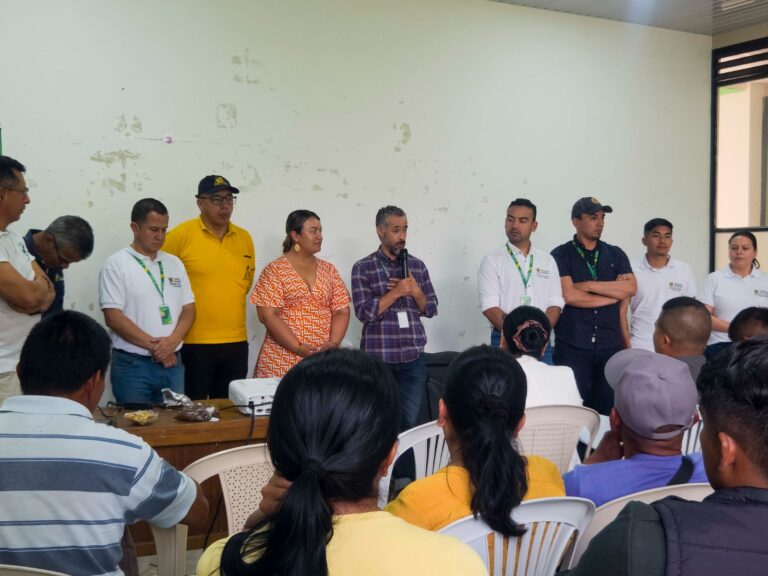 Panel de expertos y funcionarios durante el conversatorio "Paz con Aroma de Café" en Ricaurte, escuchando la intervención de un ponente frente a la comunidad.