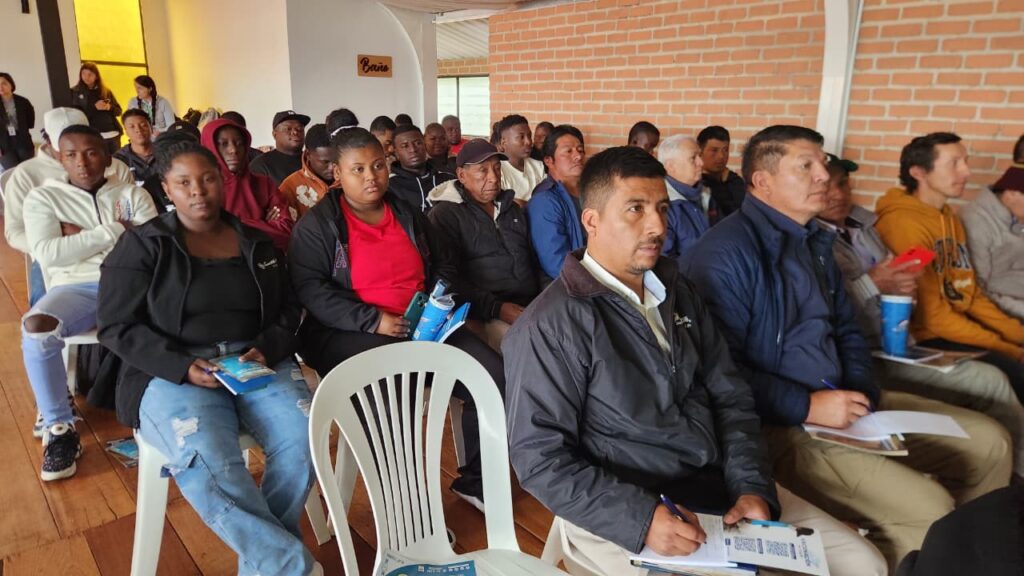 Asistentes, incluidos productores, académicos y miembros de la comunidad, sentados en filas de sillas en el Foro 'Piscicultura sin Fronteras', escuchando atentamente durante el evento en el corregimiento de El Encano.