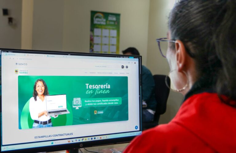 Persona consultando el portal 'Tesorería en Línea' de la Gobernación de Nariño en un monitor de computadora.