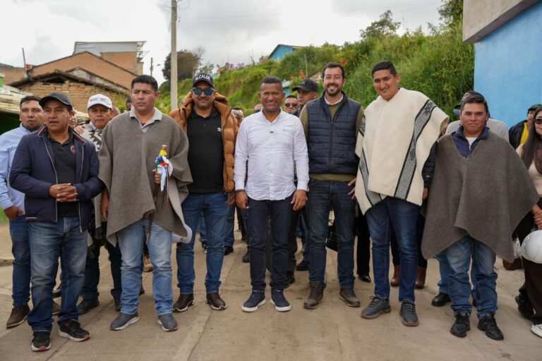 El Gobernador de Nariño, Luis Alfonso Escobar, junto al Secretario de Infraestructura, Gabriel Osejo, el Secretario de Paz, Álex González autoridades indígenas del resguardo de Túquerres y miembros de la comunidad, posan sobre un nuevo tramo de placa huella. Los líderes indígenas visten ruanas tradicionales y portan el bastón de mando.