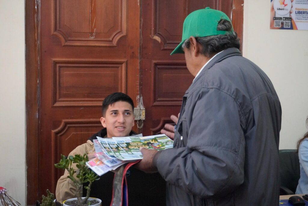 Un vendedor de lotería entrega billetes del Segundo Sorteo Extraordinario de la Lotería de Nariño a un ciudadano en Pasto.