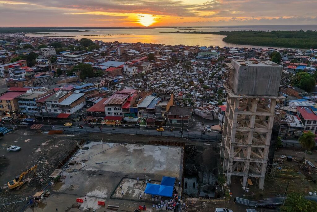 Vista aérea de Tumaco, Nariño, mostrando el avance de la construcción de un tanque elevado del acueducto y la zona de intervención urbana al atardecer.   