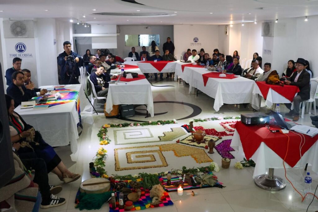 Sesión de instalación del Consejo Mayor de Gobernanza Universitaria de UNIPUEBLOS en Ipiales, con la presencia de autoridades indígenas, representantes gubernamentales y un altar ancestral en el centro del salón.