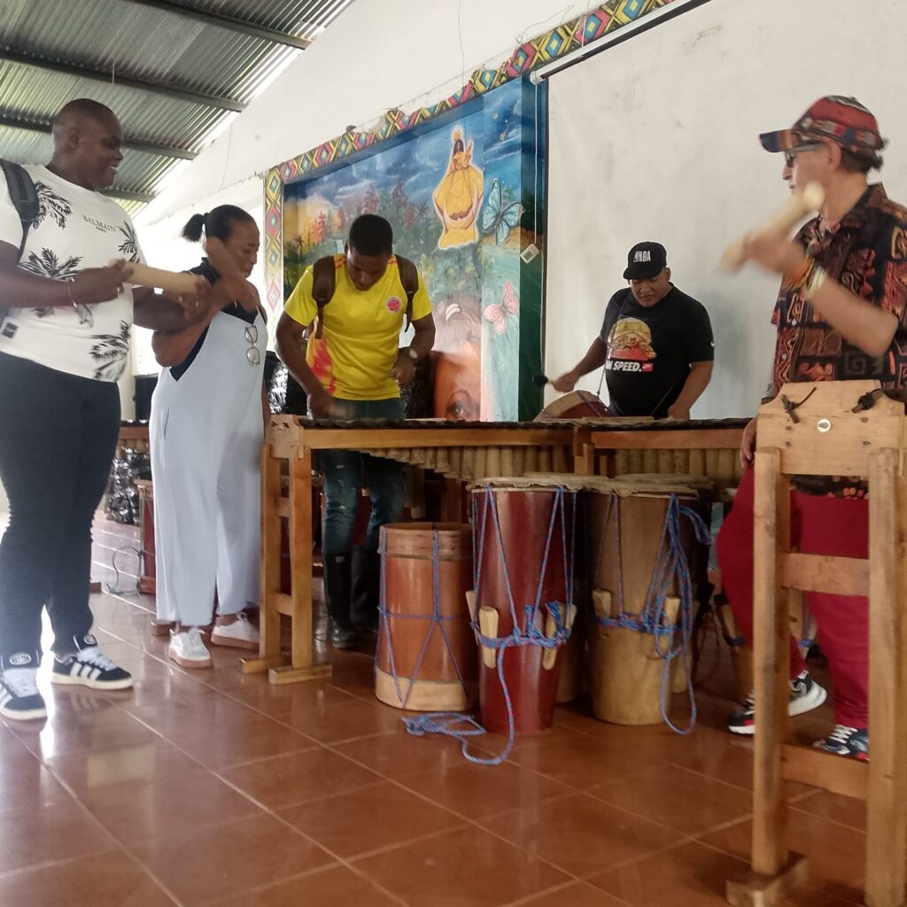 Un grupo de personas de la comunidad del Pacífico prueba y toca instrumentos tradicionales como marimbas, cununos y bombos durante una jornada de entrega cultural.