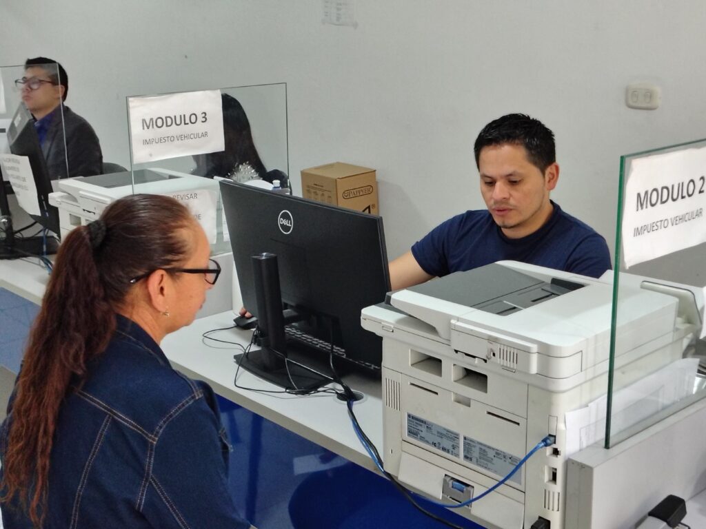 Funcionario de la Gobernación de Nariño atendiendo a una ciudadana en los módulos de servicios tributarios y consulta de impuestos.