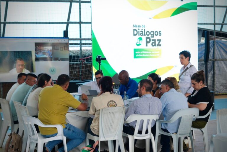 Integrantes de la Mesa de Diálogos de Paz reunidos alrededor de una mesa de trabajo en el resguardo indígena Inda Zabaleta de Tumaco.