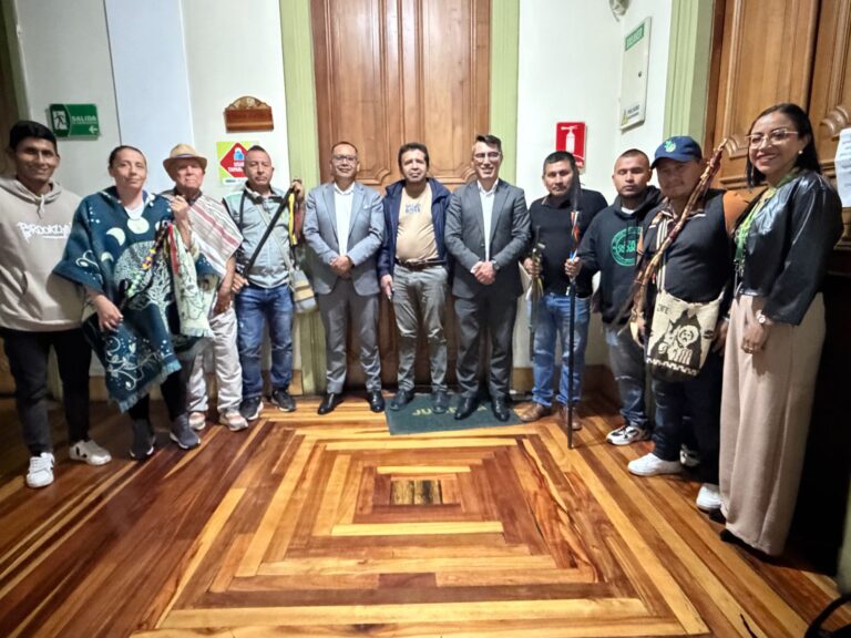 Foto grupal de funcionarios de la Gobernación de Nariño, entre ellos el secretario de Gobierno Fredy Gámez, junto a autoridades y gobernadores de las comunidades indígenas con sus bastones de mando en el pasillo de la sede administrativa.