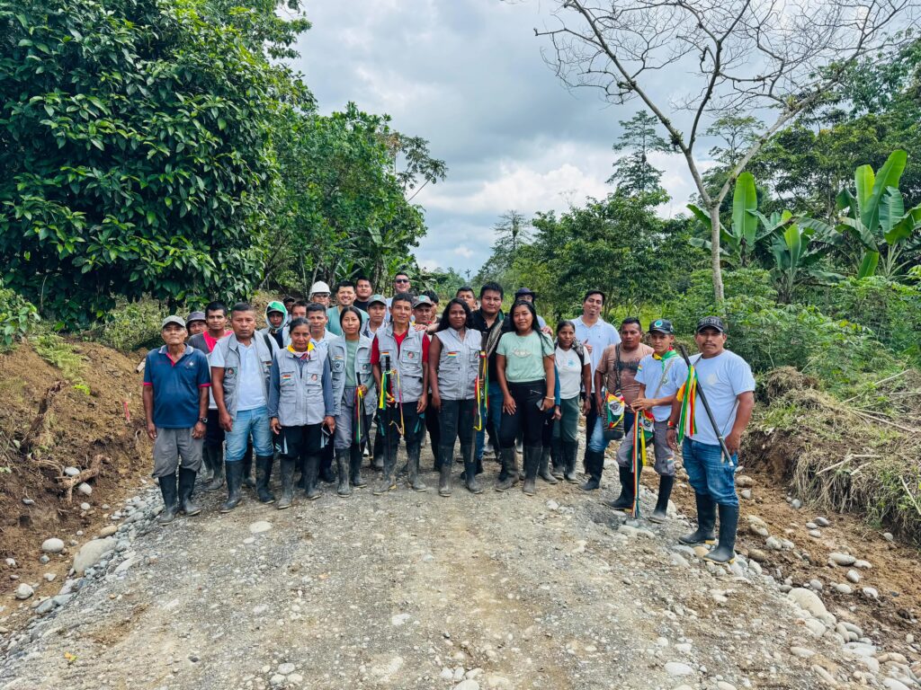 Líderes y familias de la UNIPA posan de pie sobre el nuevo tramo vial de material pétreo en el Resguardo Piedra Sellada, municipio de Tumaco.