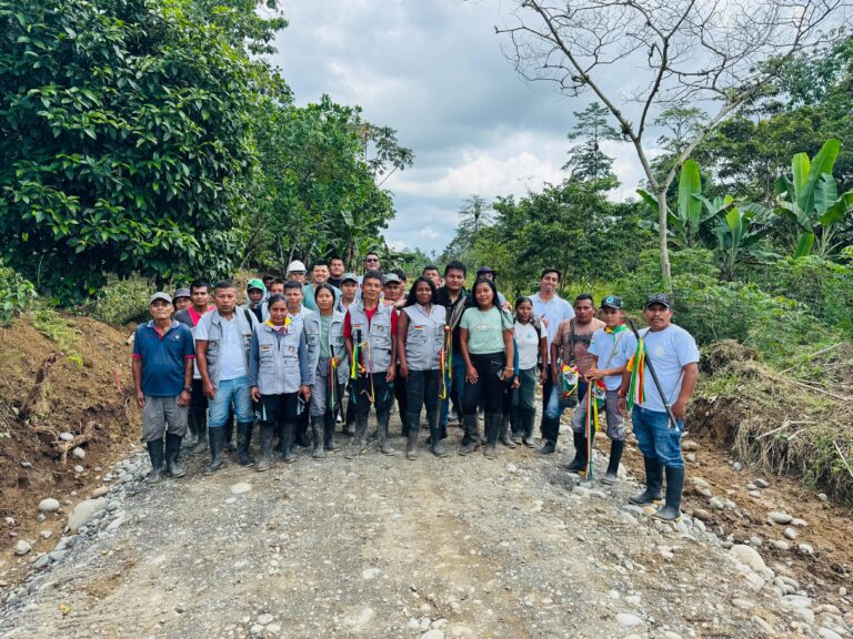 Líderes y familias de la UNIPA posan de pie sobre el nuevo tramo vial de material pétreo en el Resguardo Piedra Sellada, municipio de Tumaco.