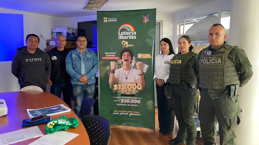 Funcionarios de la Lotería de Nariño, autoridades municipales y miembros de la Policía Nacional posan junto al pendón oficial de la estrategia de legalidad.