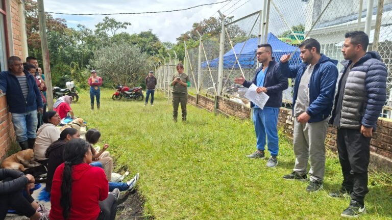Equipo de veterinarios de la Gobernación de Nariño brindando una charla de socialización a los habitantes de un corregimiento rural de Pasto sentados en el césped junto a sus perros, en el marco de la jornada móvil de esterilización gratuita.