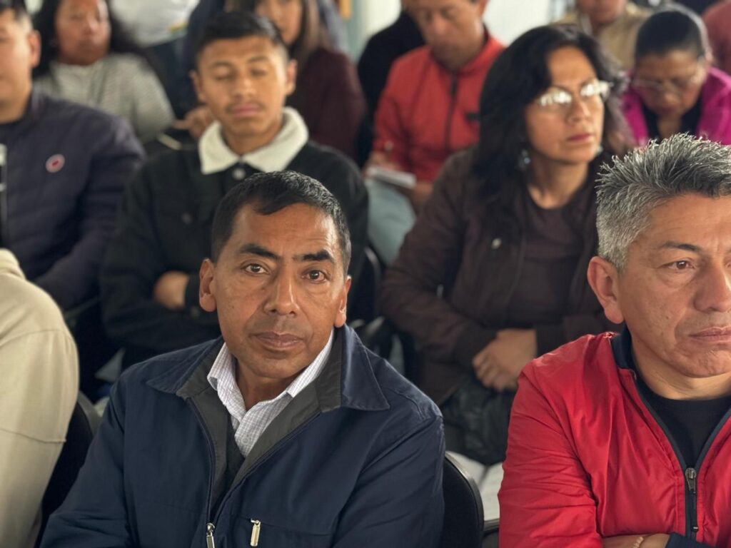 Asistentes y representantes de organizaciones sociales de base sentados en primer plano atendiendo la capacitación empresarial de la Gobernación.
