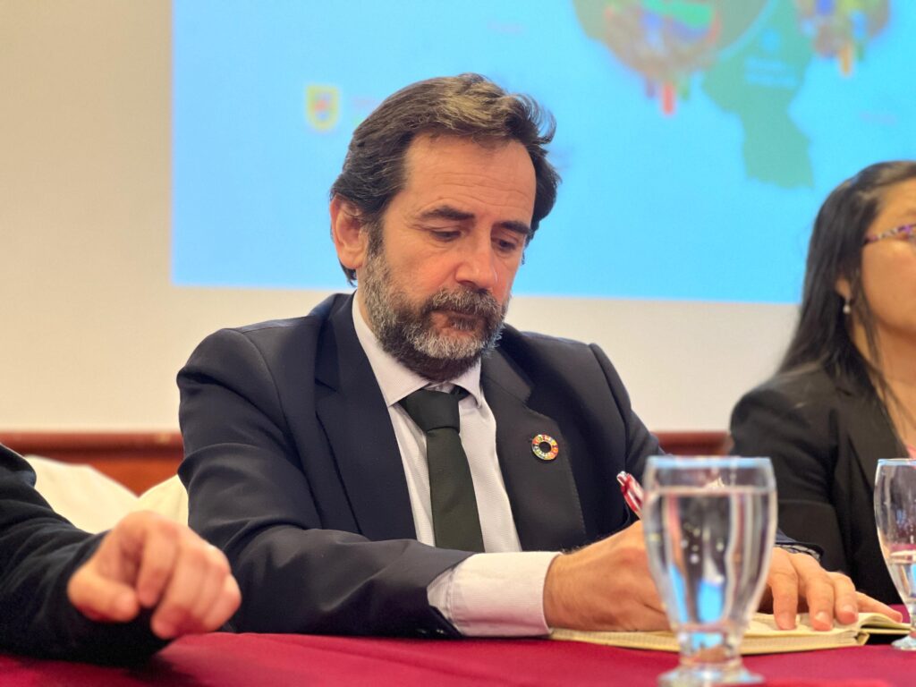 Javier Cortés, director de la Agencia Vasca de Cooperación y Solidaridad (eLankidetza), toma apuntes durante la Conferencia sobre los Nuevos Marcos de la Cooperación Descentralizada en Pasto. Lleva un pin de los Objetivos de Desarrollo Sostenible (ODS) en su traje.
