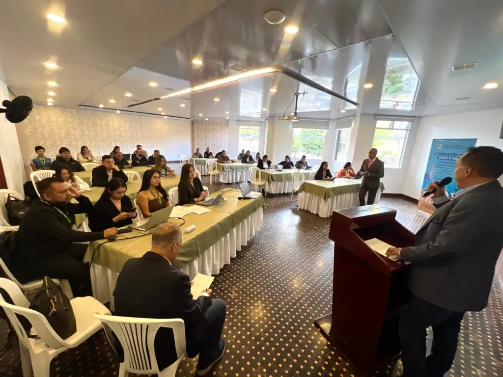 Vista general de un salón de conferencias donde un funcionario expone desde el atril frente a los asistentes del Comité Departamental de Seguridad Vial, quienes prestan atención en mesas organizadas.