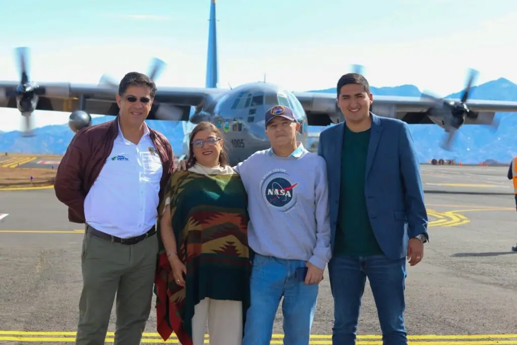 Alberto Quijano Vodniza junto a la delegación de recepción en la pista de aterrizaje con el avión Hércules al fondo.