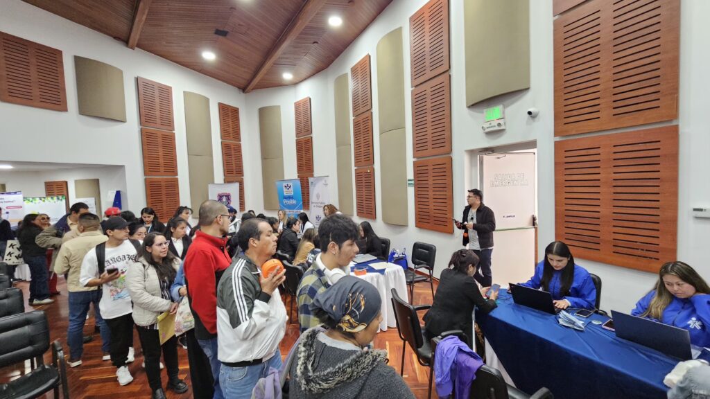 Asistentes en fila y personal de atención con computadores portátiles durante la Feria de Inclusión Laboral para Personas con Discapacidad en Nariño.