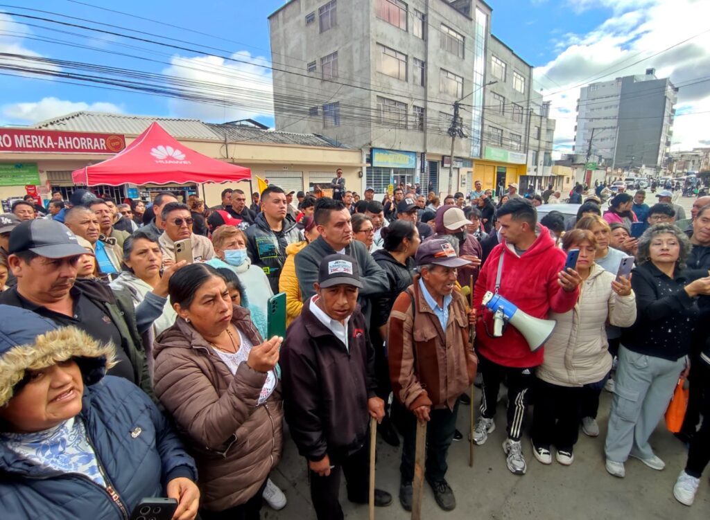 Un grupo de ciudadanos se manifiesta en una calle de Ipiales, portando un megáfono y teléfonos móviles, mientras la Gobernación de Nariño acompaña una mesa de diálogo para abordar la crisis del agua.