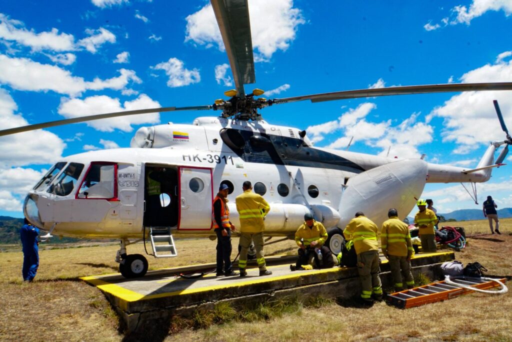 Helicóptero MI-8MTV-1 con matrícula HK-3911 en helipunto junto a bomberos y personal logístico alistando equipos para la atención del incendio forestal en Cumbitara.  