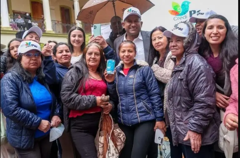 Beneficiarias y beneficiarios posando sonrientes junto al Gobernador Luis Alfonso Escobar luciendo gorras del programa CrediPaz.