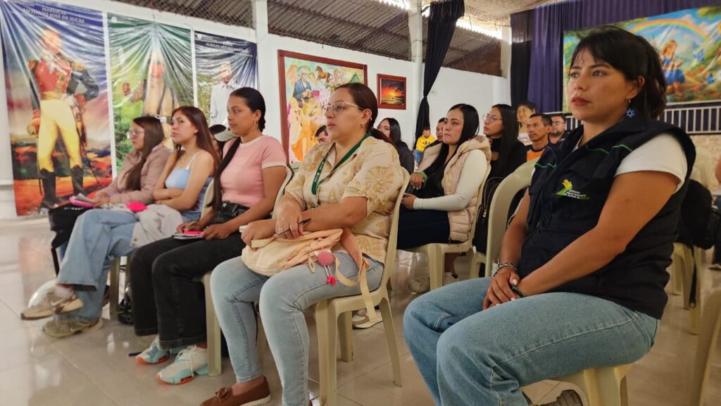 Asistentes y delegadas sectoriales sentadas en primera fila atienden la capacitación sobre planes de contingencia subregionales.