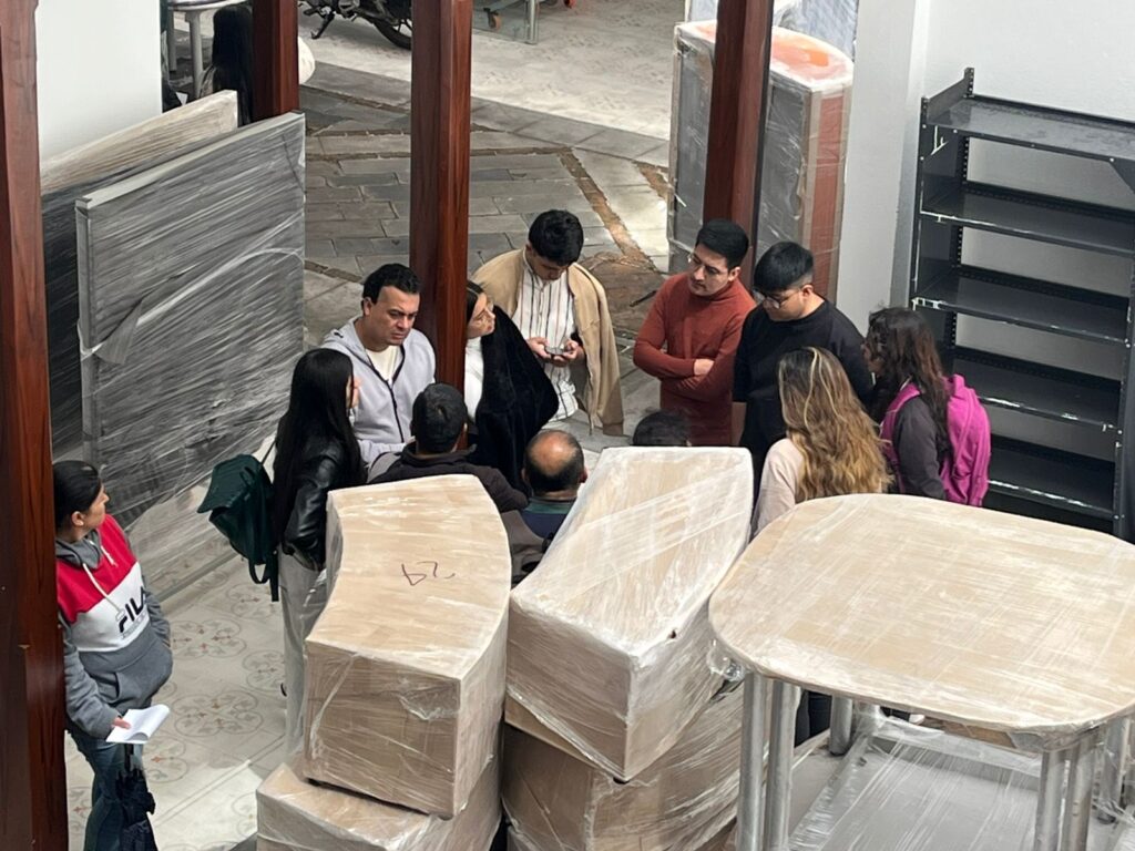 Un grupo de funcionarios de la Gobernación de Nariño supervisa la entrega y desembalaje de nuevo mobiliario para las bibliotecas públicas del departamento.  
