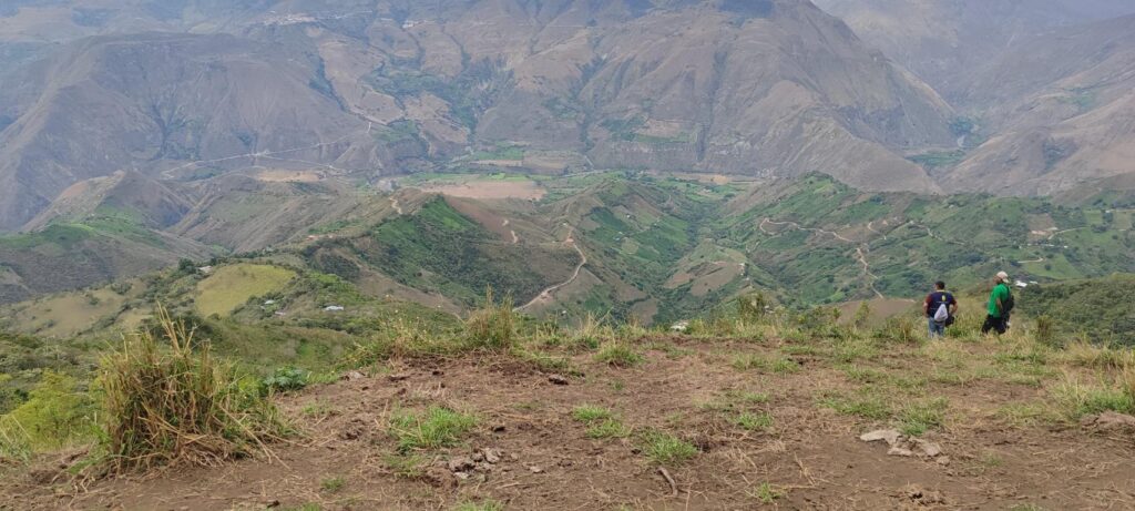 Vista panorámica del terreno escarpado y las fuertes pendientes en la zona alta de Cumbitara, Nariño, donde se evalúa la afectación por incendios forestales. Dos técnicos observan la zona desde un mirador de tierra.