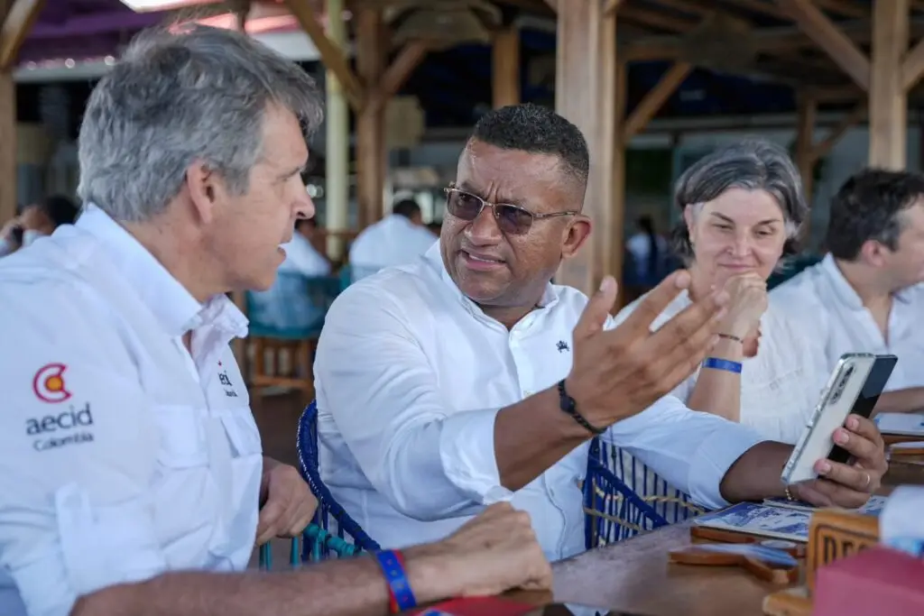 El Gobernador de Nariño, Luis Alfonso Escobar, dialoga con Miguel González, coordinador general de la Cooperación Española AECID en Colombia, mientras le enseña su teléfono celular durante la reunión en Tumaco.