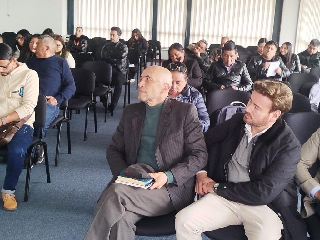 Asistentes y emprendedores del sur de Nariño escuchan atentos durante el Foro Oportunidades de las Zonas Francas de Economía Popular en Ipiales. En primer plano se observa al Asesor Javier Cabezas Castillo junto a un empresario del sector.