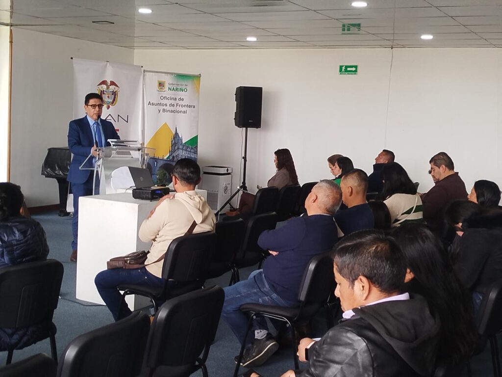 Expositor interviene desde el atril frente a los asistentes en el foro de Zonas Francas de Economía Popular en Ipiales. Al fondo se encuentran los pendones institucionales de la DIAN y de la Oficina de Asuntos de Frontera y Binacional de la Gobernación de Nariño.
