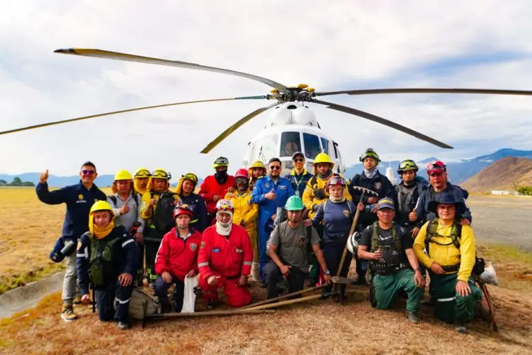Grupo de bomberos voluntarios de varios municipios de Nariño, personal de la DAGRD y la Fuerza Aeroespacial posan frente a un helicóptero tras controlar el incendio en el cerro Aminda, Cumbitara.