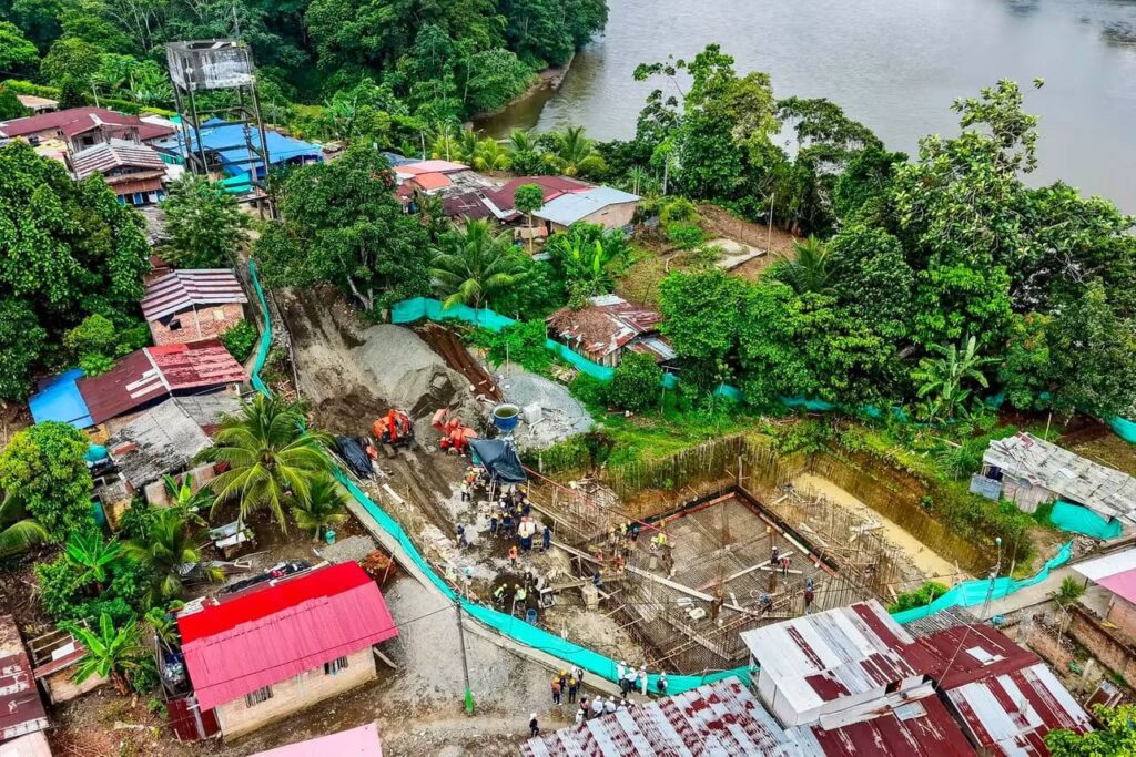 Vista aérea de la obra de optimización del acueducto en Candelillas, Tumaco, mostrando la cimentación de un tanque de almacenamiento rodeado de vegetación y viviendas