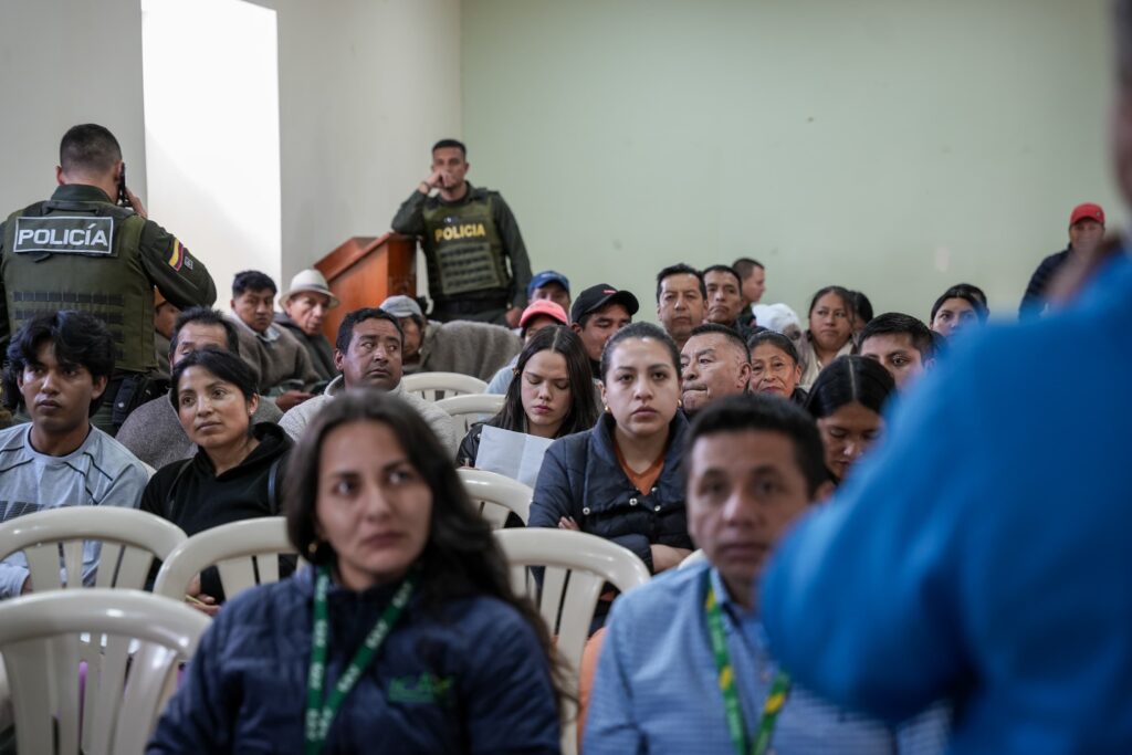Ciudadanos, miembros de la comunidad indígena, agentes de la Policía Nacional y funcionarios con identificaciones del ICA y el INVIMA sentados en un auditorio durante el foro en Cumbal.