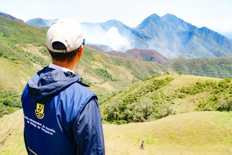 Funcionario de la DAGRD observando desde una montaña los focos de humo del incendio forestal en la zona rural de La Unión.