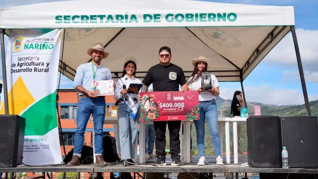 Ganador del primer puesto de la categoría artesanal varietal sosteniendo un cheque simbólico en la tarima del certamen La Mejor Taza Nariño 2026 en La Unión.