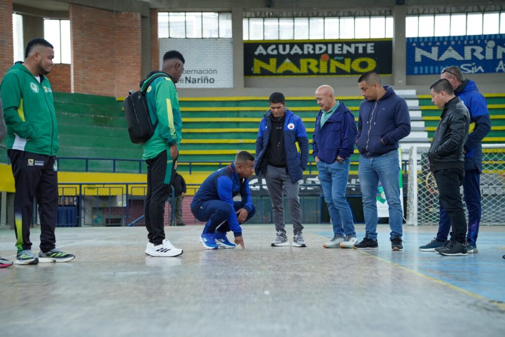 El gobernador Luis Alfonso Escobar agachado inspeccionando el estado del maderamen en el Coliseo de los Barrios Surorientales.