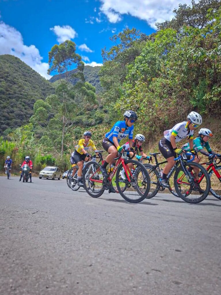Grupo de ciclistas compitiendo en carretera de montaña durante la Vuelta a Nariño.  