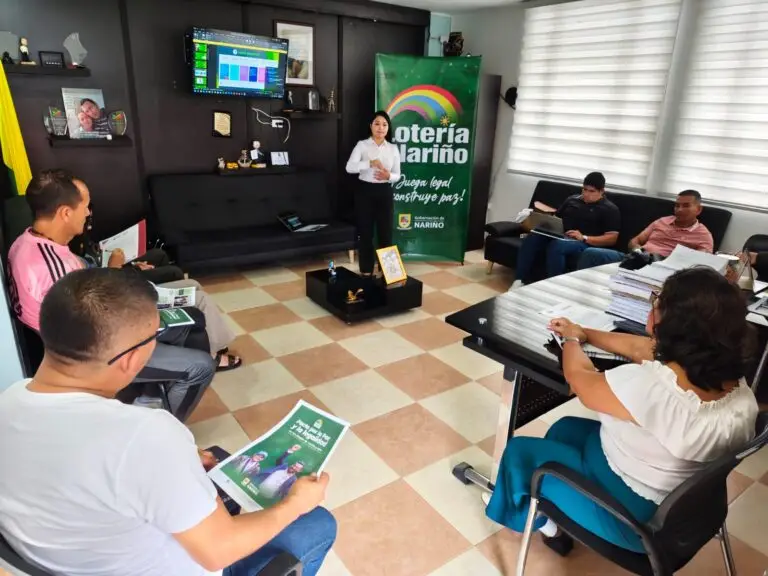 Capacitación de la Lotería de Nariño sobre el pacto por la legalidad con funcionarios en una oficina municipal.