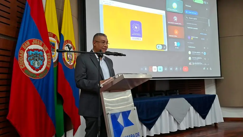Daniel Payán, rector de la Institución Educativa Agropecuaria del Río Sanquianga de Olaya Herrera, interviniendo desde un atril al lado de las banderas institucionales.