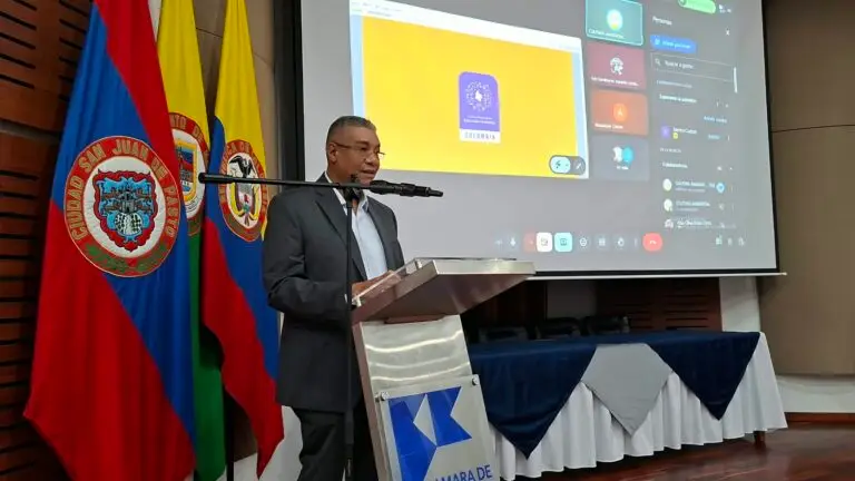Daniel Payán, rector de la Institución Educativa Agropecuaria del Río Sanquianga de Olaya Herrera, interviniendo desde un atril al lado de las banderas institucionales.