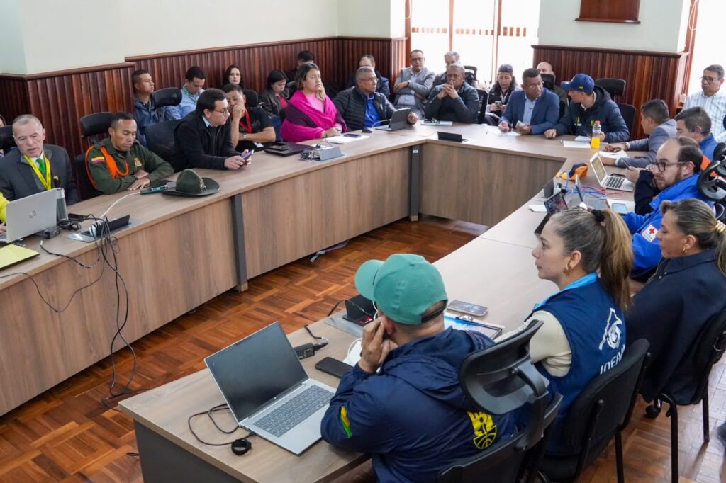 Reunión del Consejo Departamental de Gestión del Riesgo de Desastres de Nariño en una mesa de juntas con autoridades e instituciones.  