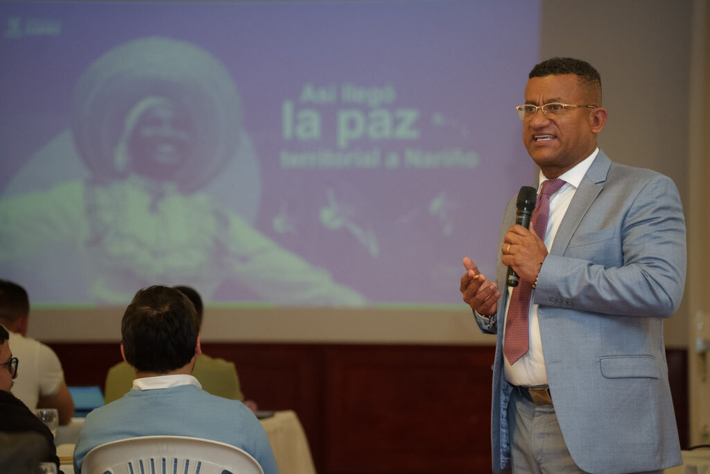 El Gobernador de Nariño, Luis Alfonso Escobar Jaramillo, interviene con micrófono en mano frente a un auditorio durante una presentación sobre los avances de la paz territorial en el departamento.