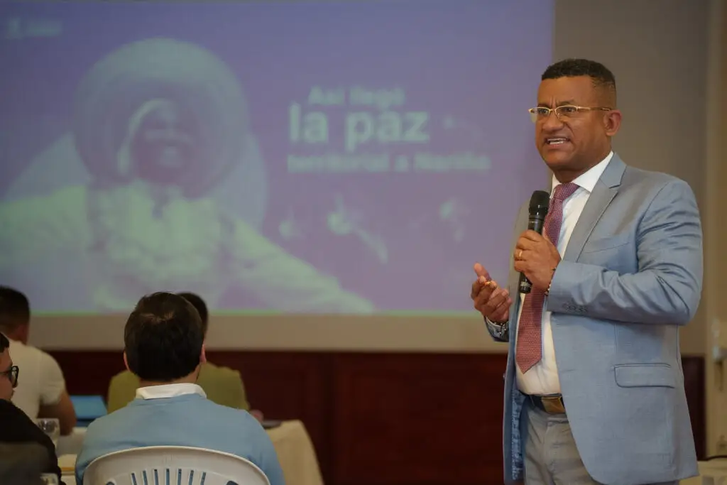 El Gobernador de Nariño, Luis Alfonso Escobar Jaramillo, interviene con micrófono en mano frente a un auditorio durante una presentación sobre los avances de la paz territorial en el departamento.