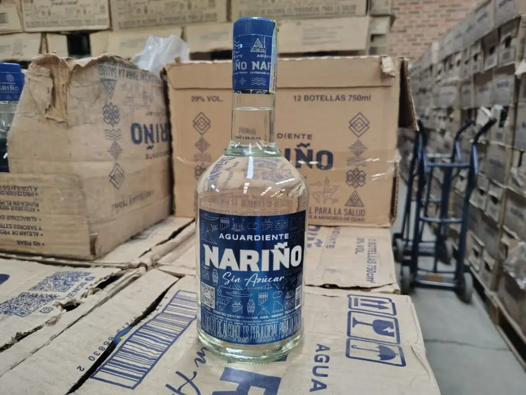 Botella de Aguardiente Nariño Sin Azúcar de 750 ml sobre cajas de cartón en bodega de distribución.