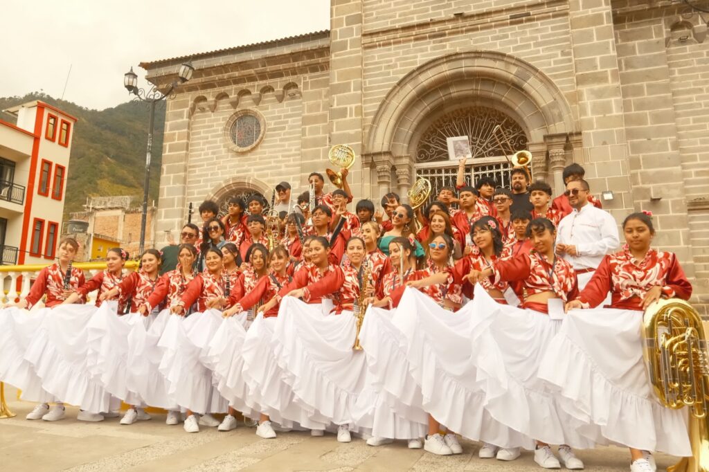  Integrantes de una banda musical juvenil posando con sus trajes folclóricos e instrumentos frente al templo principal de Samaniego.  