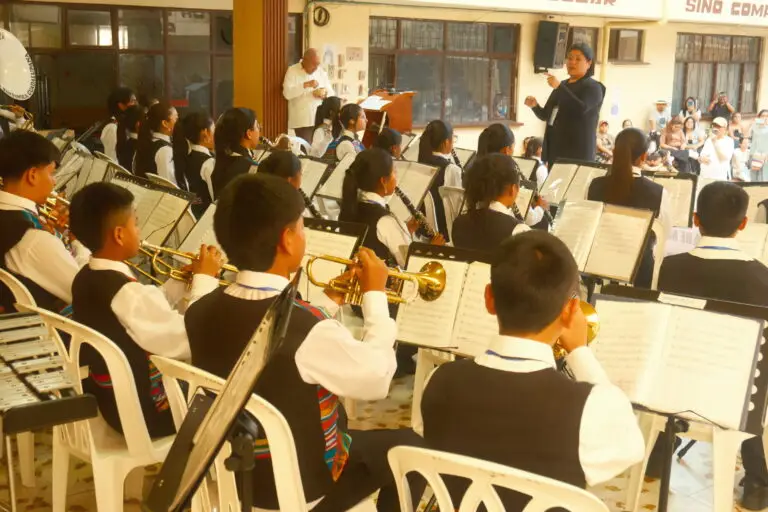 Integrantes de una banda musical infantil interpretando sus instrumentos bajo la guía de una directora durante el concurso en Samaniego.