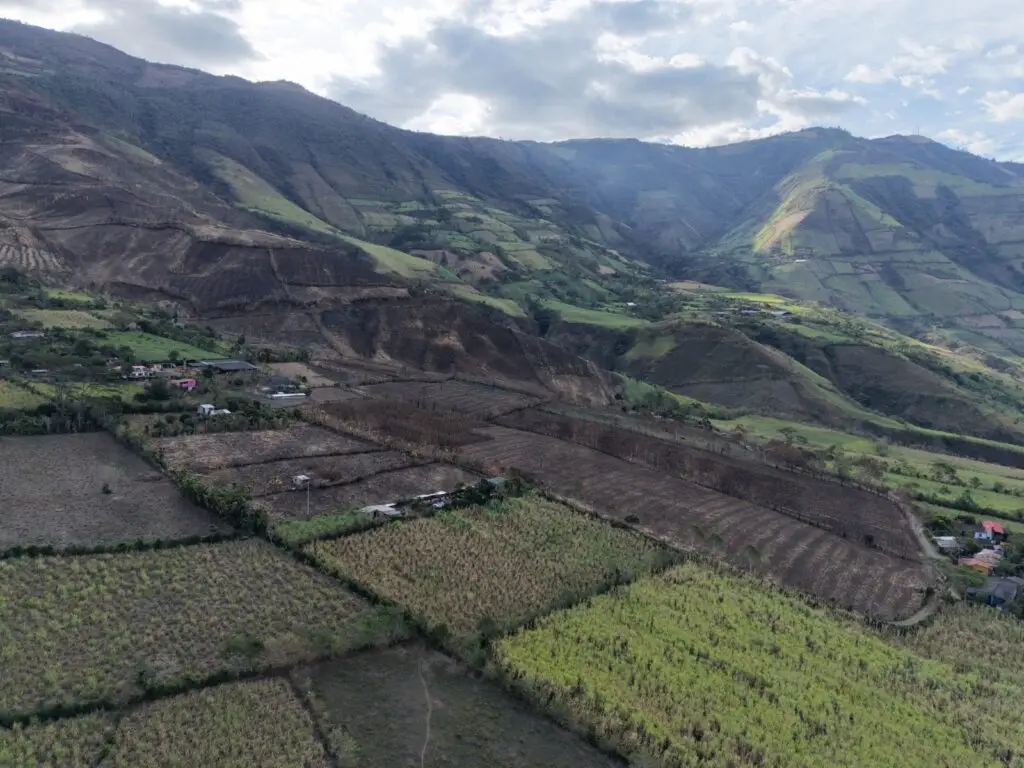 Toma aérea de parcelas agrícolas divididas y zonas de ladera montañosa en el sector rural de Nariño, mostrando terrenos de cultivo y áreas expuestas a incendios de cobertura vegetal.