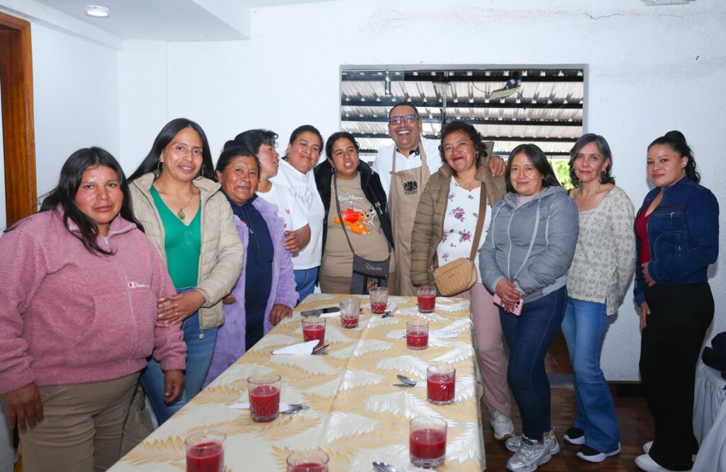 El secretario de Educación, Adrián Zeballos, sonríe junto a un grupo de manipuladoras de alimentos del PAE reunidas alrededor de una mesa.